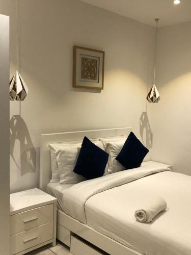 a bedroom with two beds with blue pillows at Embassy gardens by Cosy Retreat Apartments in Cantonments