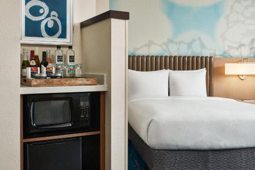a hotel room with a bed and a microwave at Courtyard by Marriott Faro Blanco Resort in Marathon