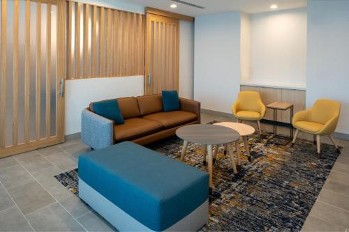 a waiting room with a couch and two chairs at TownePlace Suites by Marriott Pensacola West I-10 in Pensacola