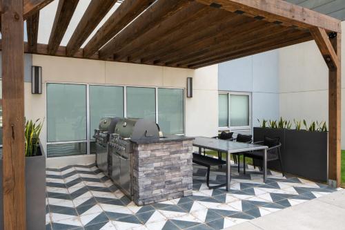 an outdoor patio with a grill and a table at TownePlace Suites by Marriott Pensacola West I-10 in Pensacola