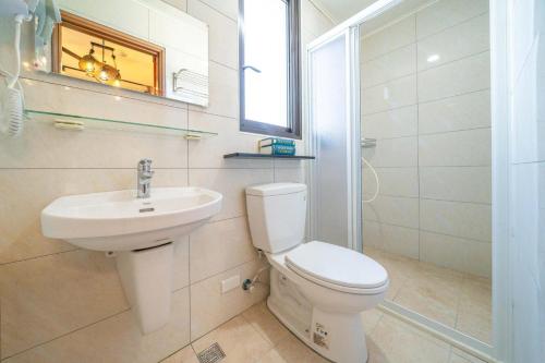 a white bathroom with a toilet and a sink at 寵物友善-無門禁24小時進出-竹蜻蜓民宿 in Wujie