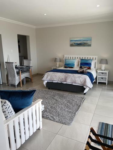 a bedroom with a bed with blue pillows at De Santa Villas in St Helena Bay