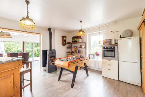 une cuisine avec une table et un échiquier. dans l'établissement Grande Maison, les pieds dans l'eau, Vacances Bord de Mer (50m de la plage)., à Penvénan