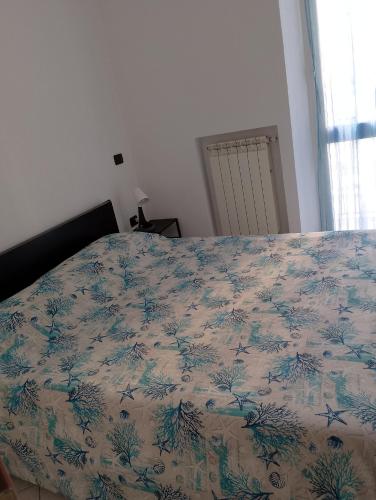 a bed in a bedroom with a blanket on it at Casa Stella in Savona