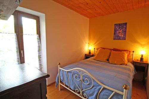 a bedroom with a bed in a room with a window at Le vieil orme in Saint-Junien