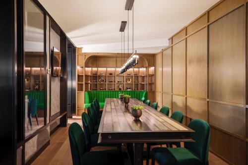 a conference room with a long table and green chairs at Renaissance New York Flushing Hotel at Tangram in Queens