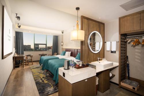 a hotel room with a bed and a sink at Mehood Lestie, Zhangbaliu Road, Xi'an High-tech Zone in Chang'an