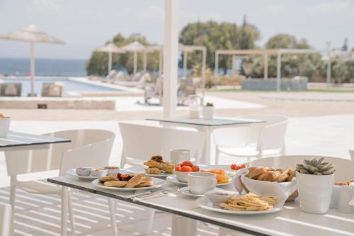 a table with plates of food on top of it at Ambelas Mare Apartments in Ambelas