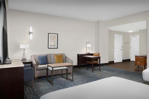 a hotel room with a couch and a desk at Homewood Suites Dallas Downtown in Dallas