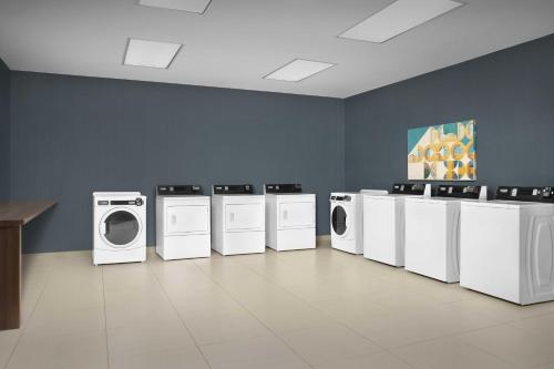 a laundry room with white washing machines and a painting at Homewood Suites Dallas Downtown in Dallas