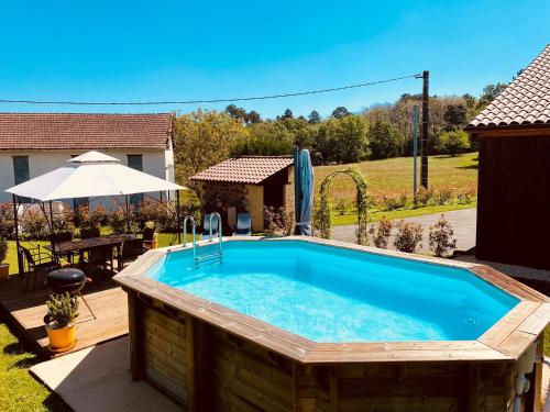 - une piscine dans une cour avec une table et un parasol dans l'établissement 3-Star Tourism Rated Holiday Home with Air Con and Private Heated Pool - 45 Mins from Sarlat, à Capdrot
