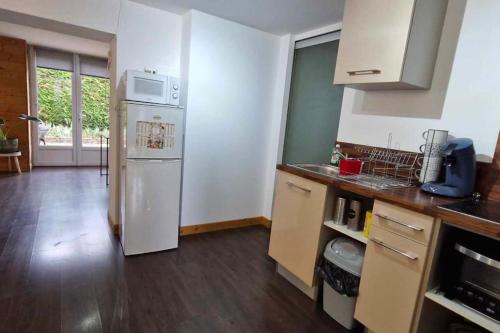 a kitchen with a white refrigerator in a room at L'Ain-parfait in Saint-Étienne-du-Bois