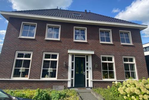 a red brick house with a green door at Room D no bathroom, geen badkamer in Aalten