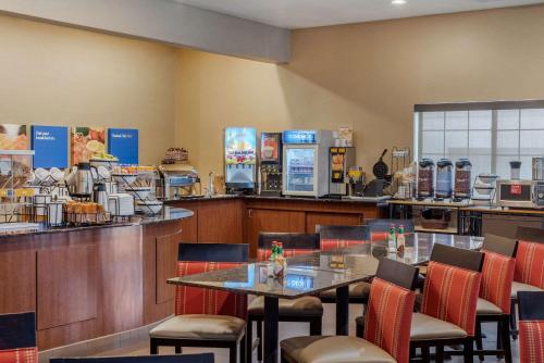 a restaurant with tables and chairs and a counter at Comfort Inn & Suites Alamosa in Alamosa