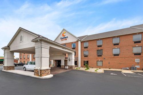 a hotel with a car parked in a parking lot at Comfort Suites Louisville Airport in Louisville