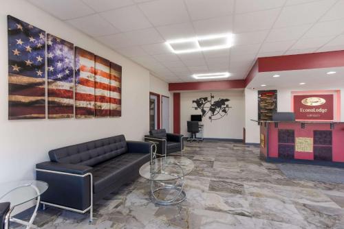 a waiting room with a couch and a flag on the wall at Econo Lodge Cave City in Cave City