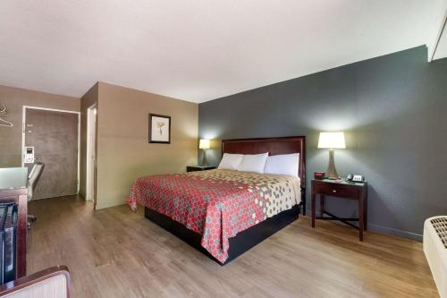 a hotel room with a bed with a red bedspread at Econo Lodge High Point - Archdale in High Point