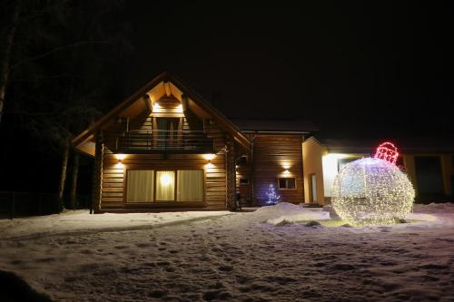 a house with a christmas decoration in the snow at night at Villa Rose & SPA in Mežciems