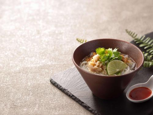 a brown bowl of soup with a lime and a garnishment at Grand Mercure Ise-shima Resort & Spa in Shima