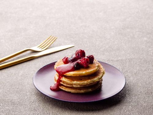 a plate with a stack of pancakes with fruit on top at Grand Mercure Ise-shima Resort & Spa in Shima