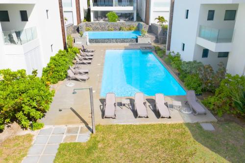 an overhead view of a swimming pool with chaise lounge chairs at White&Blue Beachfront Luxury Poste Lafayette in Poste Lafayette