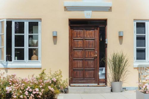 a house with a wooden door and two windows at Strandidyl Bed and Breakfast in Haderslev