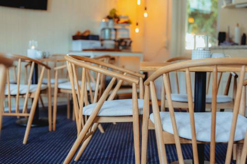 a group of chairs sitting around a wooden table at Strandidyl Bed and Breakfast in Haderslev