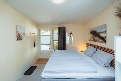 a bedroom with a large bed and a window at Strandidyl Bed and Breakfast in Haderslev