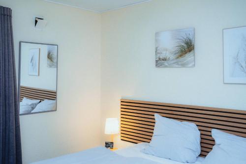 a bedroom with a bed and three pictures on the wall at Strandidyl Bed and Breakfast in Haderslev