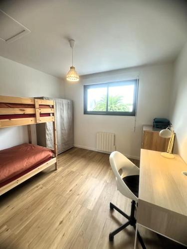 Cette chambre comprend un bureau et des lits superposés. dans l'établissement Chez Katerina - Plomeur proches plages, à Plomeur