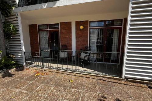 a screened in porch of a house with a fence at Retro City Center Gem by ARPA Hospitalities in Stellenbosch