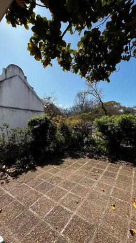 a stone walkway with bushes and a building at Retro City Center Gem by ARPA Hospitalities in Stellenbosch