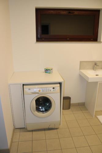 a washer and dryer in a bathroom with a sink at Villa Luna in Oudsbergen 