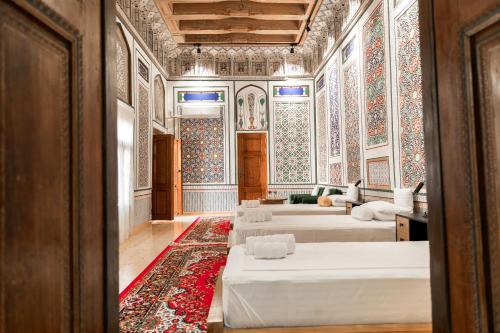 a large room with two beds and a rug at Barlos Noyob Boutique in Bukhara