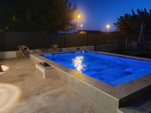 une piscine dans un jardin la nuit dans l'établissement Maison de charme, à Lapalud