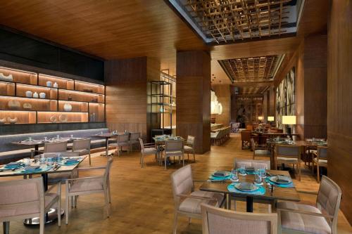 a dining room with tables and chairs and a restaurant at The Westin Mumbai Powai Lake in Mumbai