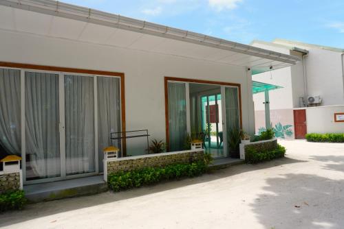 a building with glass doors on the side of it at TME Retreats Dhigurah in Dhigurah