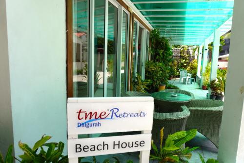 a beach house sign in front of a beach house at TME Retreats Dhigurah in Dhigurah