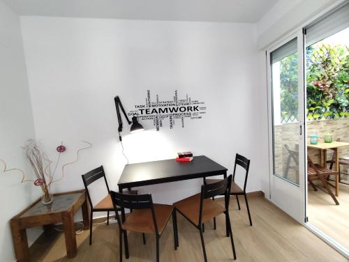 een eetkamer met een zwarte tafel en stoelen bij Apartamento Artesano Del Cuero SpaceWorking in Ubrique