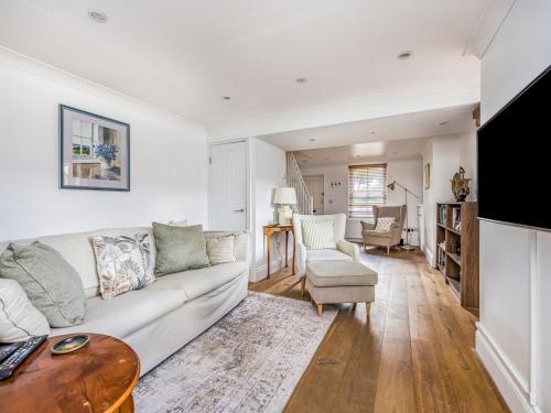 a living room with a white couch and a table at Charming Chichester Home w Garden - Pass The Keys in Chichester