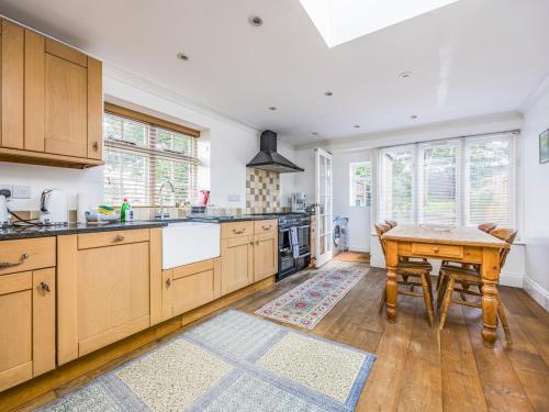 a kitchen with wooden cabinets and a wooden table at Charming Chichester Home w Garden - Pass The Keys in Chichester