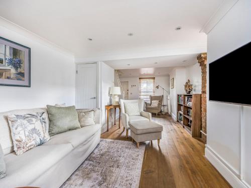 a living room with a white couch and a tv at Charming Chichester Home w Garden - Pass The Keys in Chichester