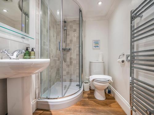 a bathroom with a shower and a sink and a toilet at Charming Chichester Home w Garden Pass The Keys in Chichester