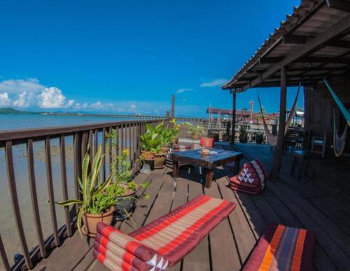 a deck with a table and chairs on the beach at Tonmai Suite II in Ko Por