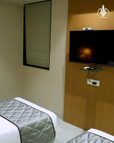 a bedroom with a bed and a flat screen tv at SIVANTA by BOMBAY GROUP OF HOTELS NAGPUR in Nagpur