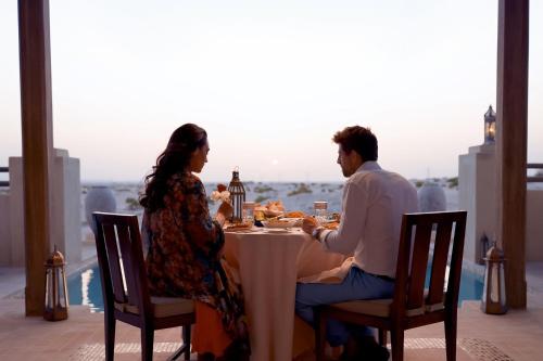a man and a woman sitting at a table at Al Wathba, a Luxury Collection Desert Resort & Spa, Abu Dhabi in Abu Dhabi
