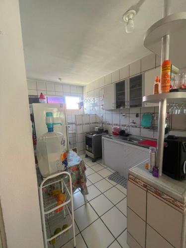 a kitchen with a refrigerator and a table in it at Apartamento Icaraí Atlântic village in Caucaia