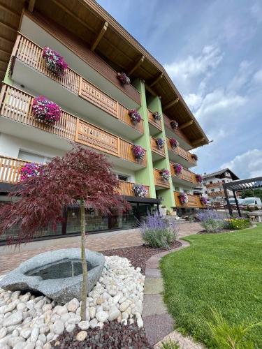 a building with a tree in front of a building at Mason La Zondra in Vigo di Fassa
