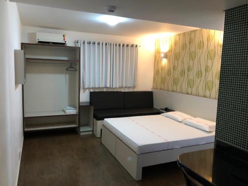 a small room with a bed and a couch at Calandre Hotel in Sao Paulo