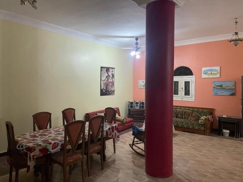 a living room with a table and a red pole at MelissaKato in Naj‘ al Maḩaţţah